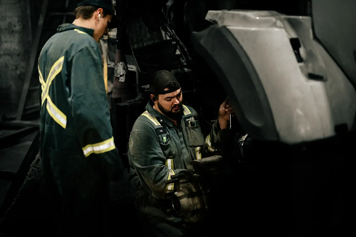 Heavy-duty diesel mechanic performing wheel repairs on semi truck.